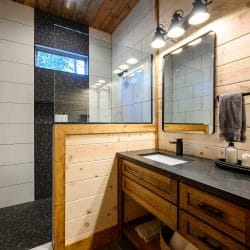 Bathroom sink beside a window into the shower