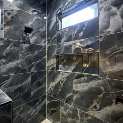 Close view of dark marble-look tile with a shower niche