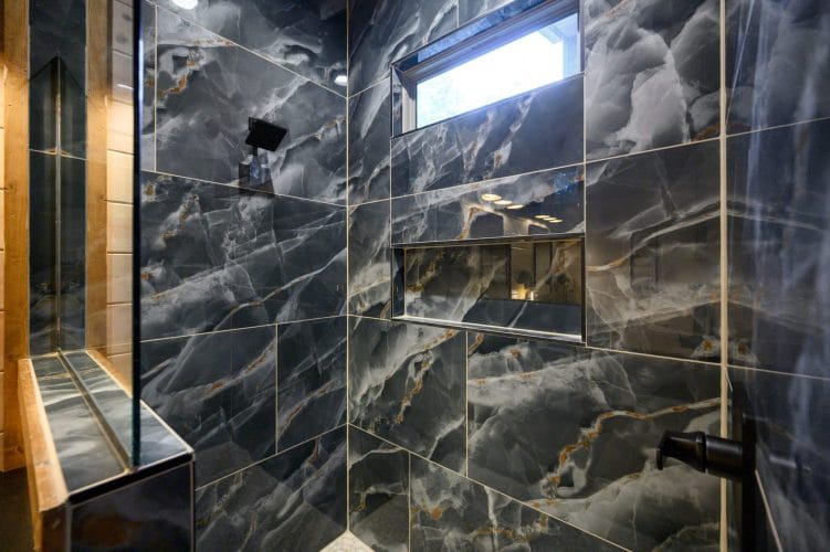 Close view of dark marble-look tile with a shower niche