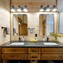 Bathroom sink with a rustic wood-framed mirror and wood door