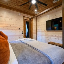 Foot of the four-post bed with a glass-paneled door to the outside