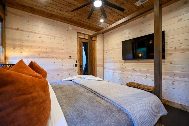 Foot of the four-post bed with a glass-paneled door to the outside