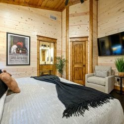 Bedroom with the bathroom doorway and a tall wood door beside it