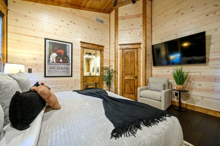Bedroom with the bathroom doorway and a tall wood door beside it