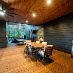 Covered patio dining table with ping pong table, outdoor TV and a bedroom door behind