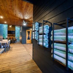 Rack of striped pool towels beside a wood-and-glass door