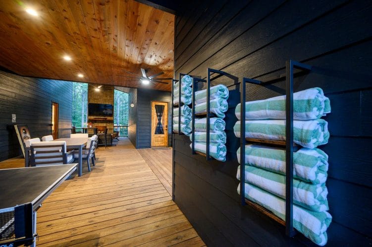 Rack of striped pool towels beside a wood-and-glass door