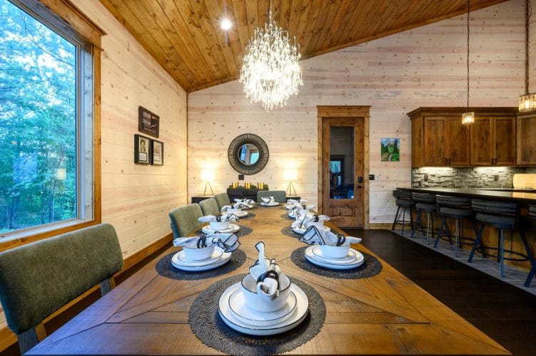 Long wooden dining table set with plates and folded napkins