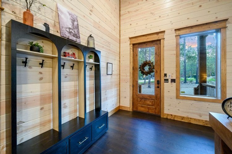 Entry hall with a wood-framed glass door, wall hooks and a framed sign