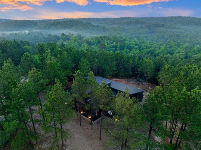 Aerial view of the cabin roof and a cleared area among pines