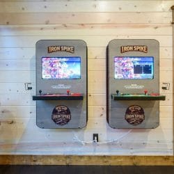 Two Iron Spike Lodge arcade machines with joysticks and game screens