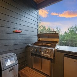 Stainless gas grill with the lid open on the porch