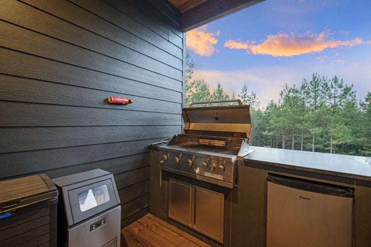 Stainless gas grill with the lid open on the porch