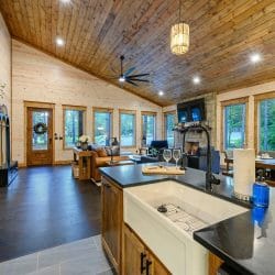Kitchen island open to the living room with a leather couch and fireplace beyond
