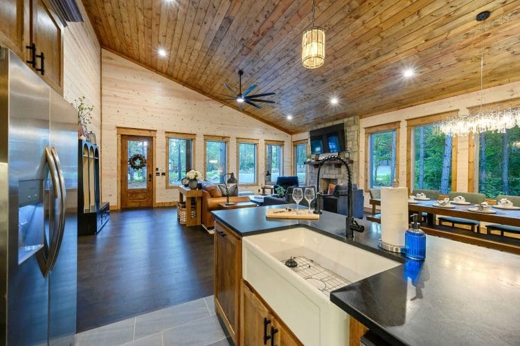 Kitchen island open to the living room with a leather couch and fireplace beyond