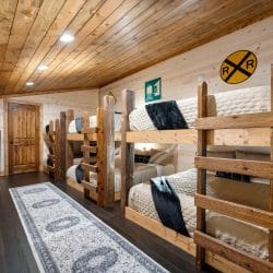 Bunk beds in the loft with a wooden ladder and dark throw blankets