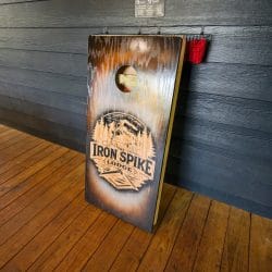 Cornhole board with the Iron Spike Lodge logo