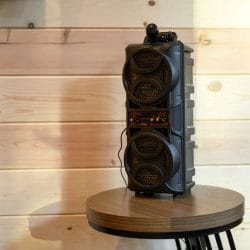 Close view of a portable speaker on a wood wall