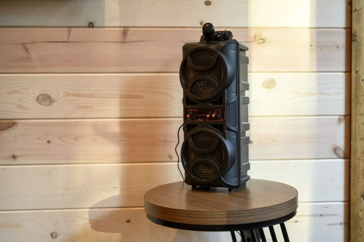 Close view of a portable speaker on a wood wall