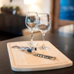 Two wine glasses on a wood board