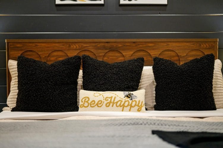 Close view of black textured and cream bee-embroidered pillows