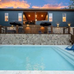 Pool and stone wall with the wood deck and loungers above