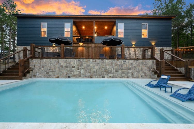 Pool and stone wall with the wood deck and loungers above