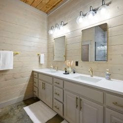 Double vanity with brass fixtures and two mirrors