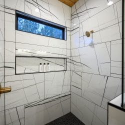 Walk-in shower with white tile veined in black