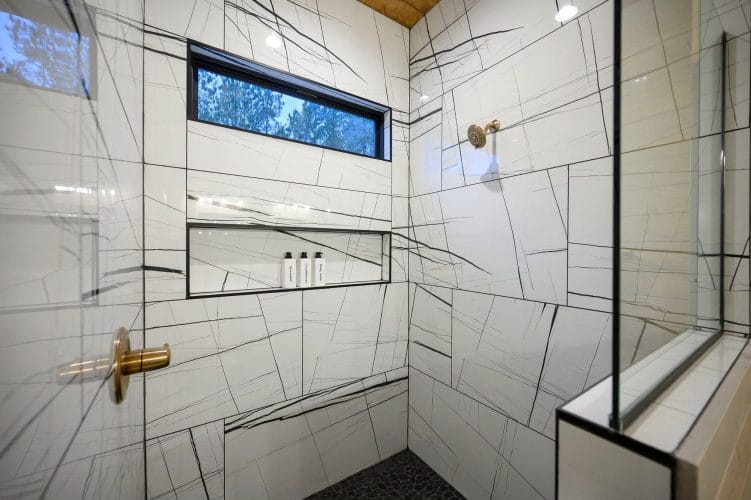 Walk-in shower with white tile veined in black
