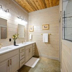 Double vanity with a window and a vase of flowers