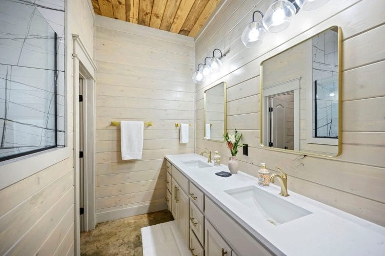 Double vanity with a gold-framed mirror