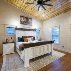 Second upstairs king bed with a white and brown frame and horse art above