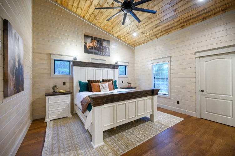 Second upstairs king bed with a white and brown frame and horse art above