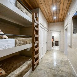 Hallway bunk beds, stacked three high, with the hall running past them