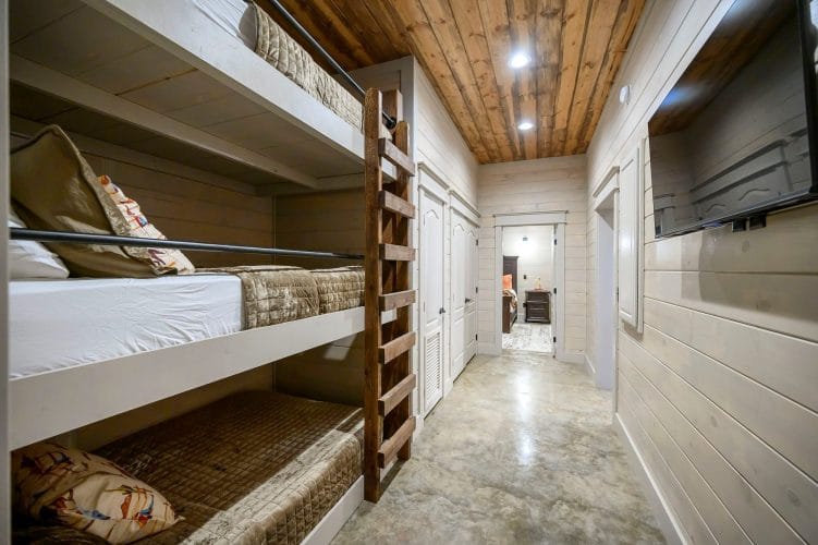 Hallway bunk beds, stacked three high, with the hall running past them