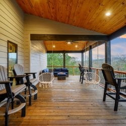 Long covered deck with tall chairs and a swing at the far end