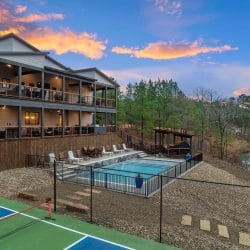 Stacked decks of the lodge above the pool, with the sports court and creek below