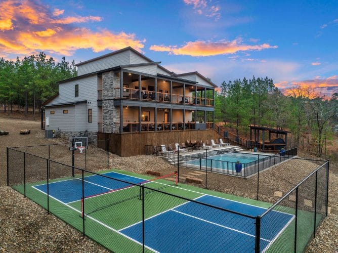 Lodge, pool and sports court with the creek beyond, at dusk