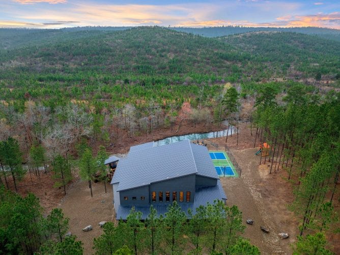 Aerial view of the lodge roof and sports court in the forest