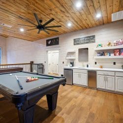 Pool table next to a bar counter with a shelf of snacks