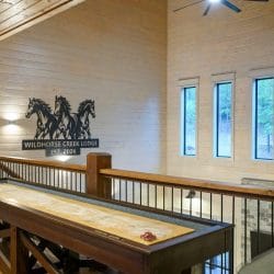 Upstairs landing with a metal horses sign and a black railing