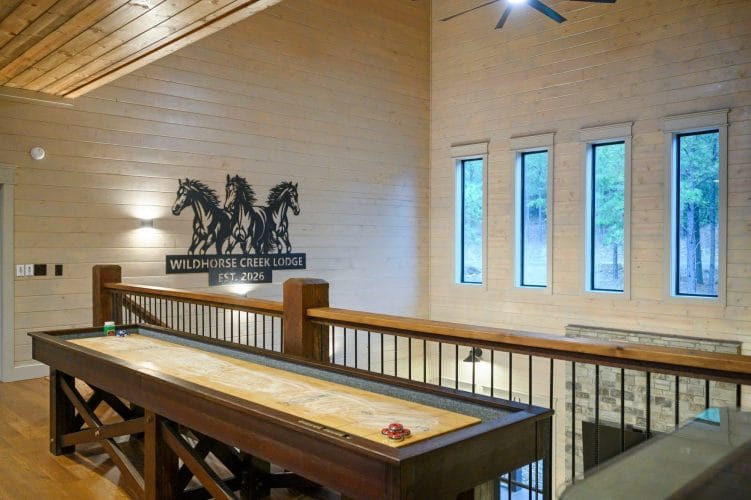 Upstairs landing with a metal horses sign and a black railing