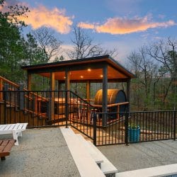 Gazebo-style covered structure with a barrel sauna beside the pool deck