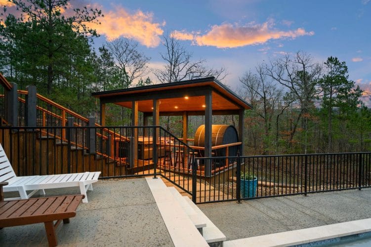 Gazebo-style covered structure with a barrel sauna beside the pool deck