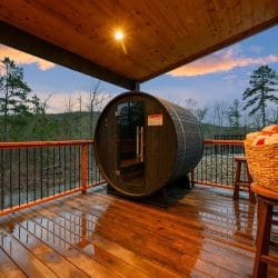 Barrel sauna on the deck with a basket of towels