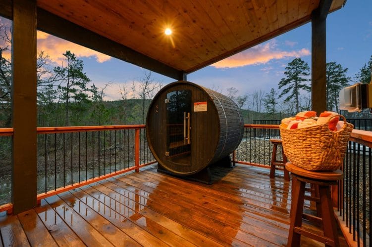Barrel sauna on the deck with a basket of towels