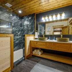 Double vanity with bowl sinks and a large tile shower