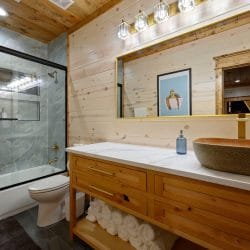 Vanity with a bowl sink and a glass tub-shower