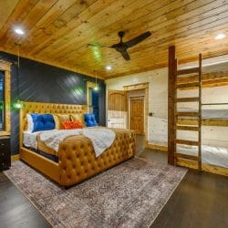 Tufted king bed with a triple-stacked bunk against the right wall